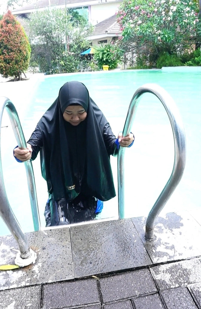 Muslim woman wearing Layyin swimwear while exiting the pool
